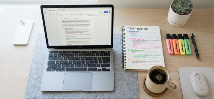 Student reviewing a color-coded essay outline on a clean study desk.