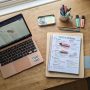 Student reviewing a digital academic portfolio layout on a laptop at a organized desk setup.